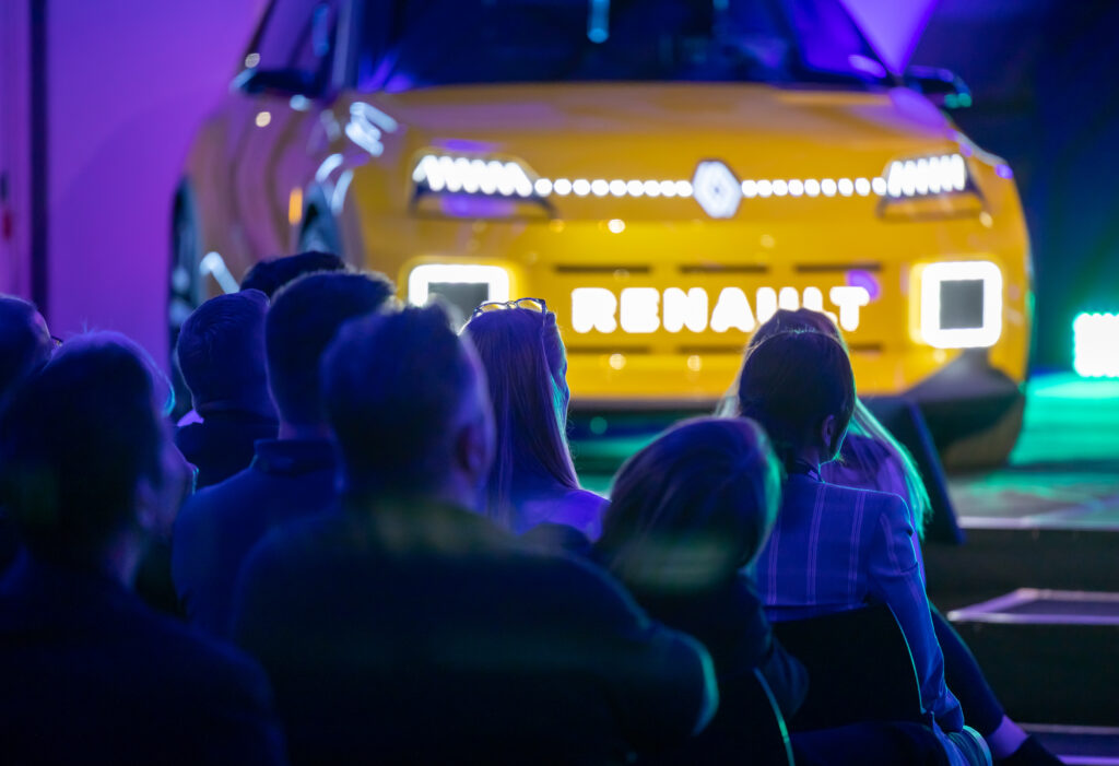 Group of delegates looking at a yellow car at a conference